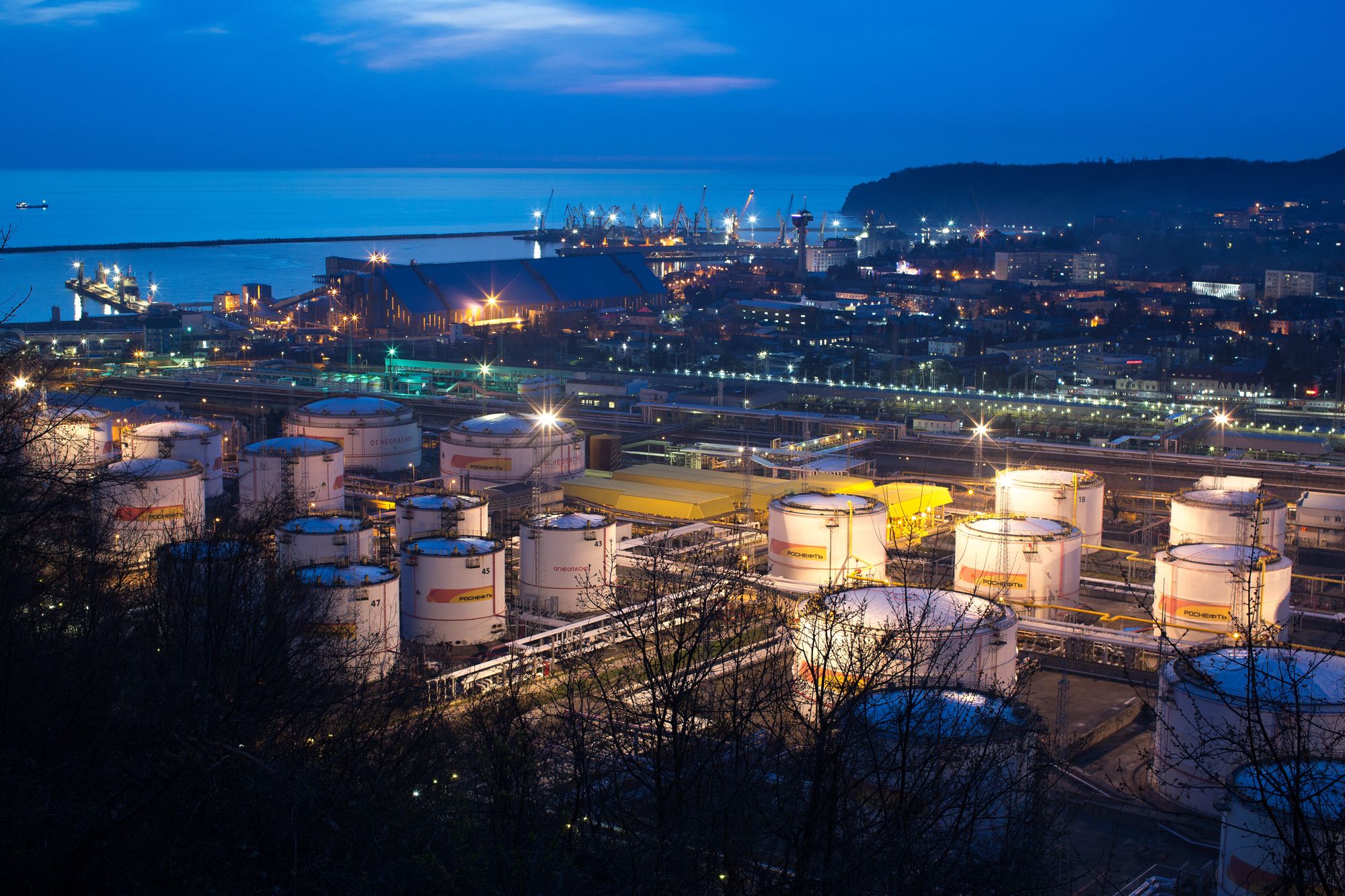 Oil storage tanks stand illuminated at night at the RN-Tuapsinsky refinery, operated by Rosneft Oil Co., in Tuapse, Russia