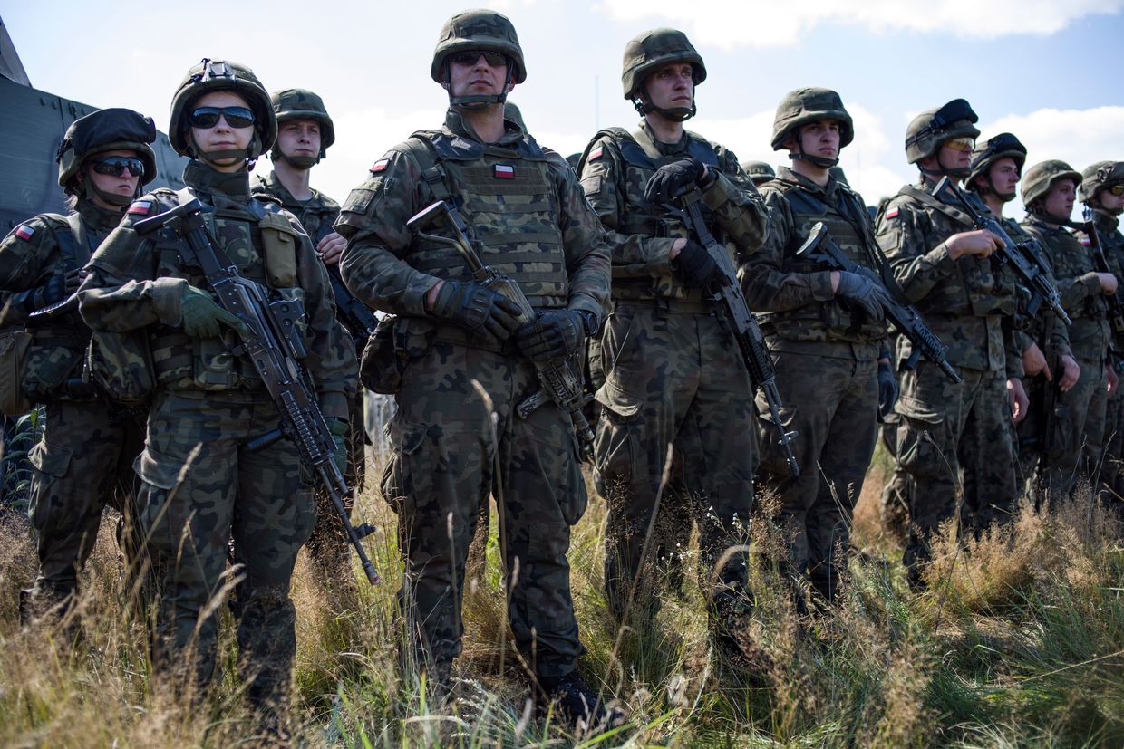 Polish servicemen attend a press conference of Poland's Defense Minister Mariusz Blaszczak at Jarylowka military camp near Poland's border with Belarus on Aug. 12, 2023. 