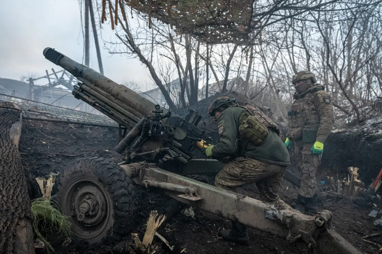 Ukrainian soldiers reload an artillery unit on the front line.
