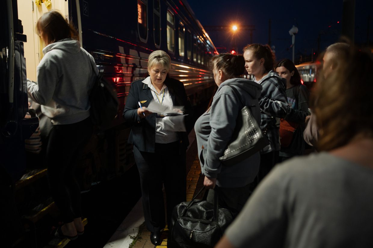 Train attendant Tetiana Kohut checks the tickets of passengers before departure to Lviv in a railway station in Kyiv