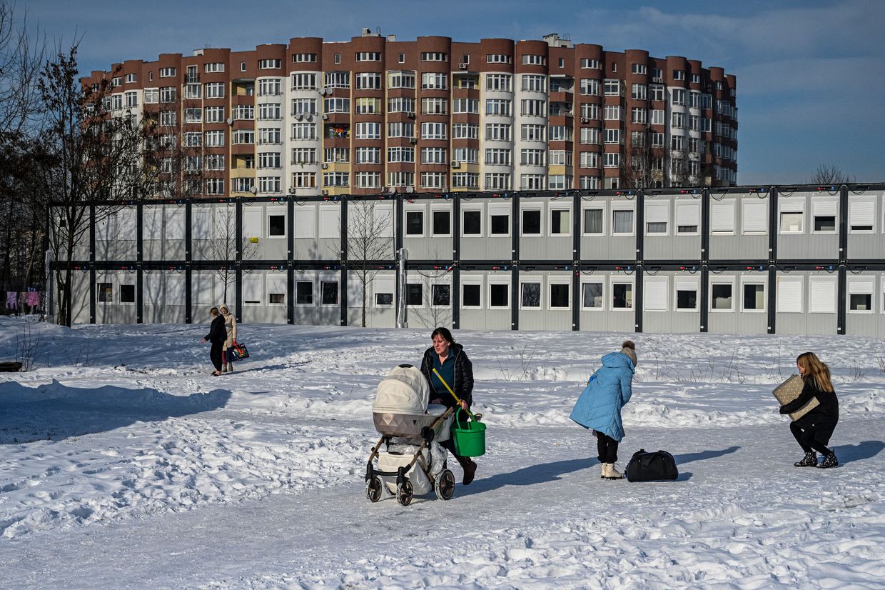 Internally displaced people walk in a modular housing complex donated by the Polish government