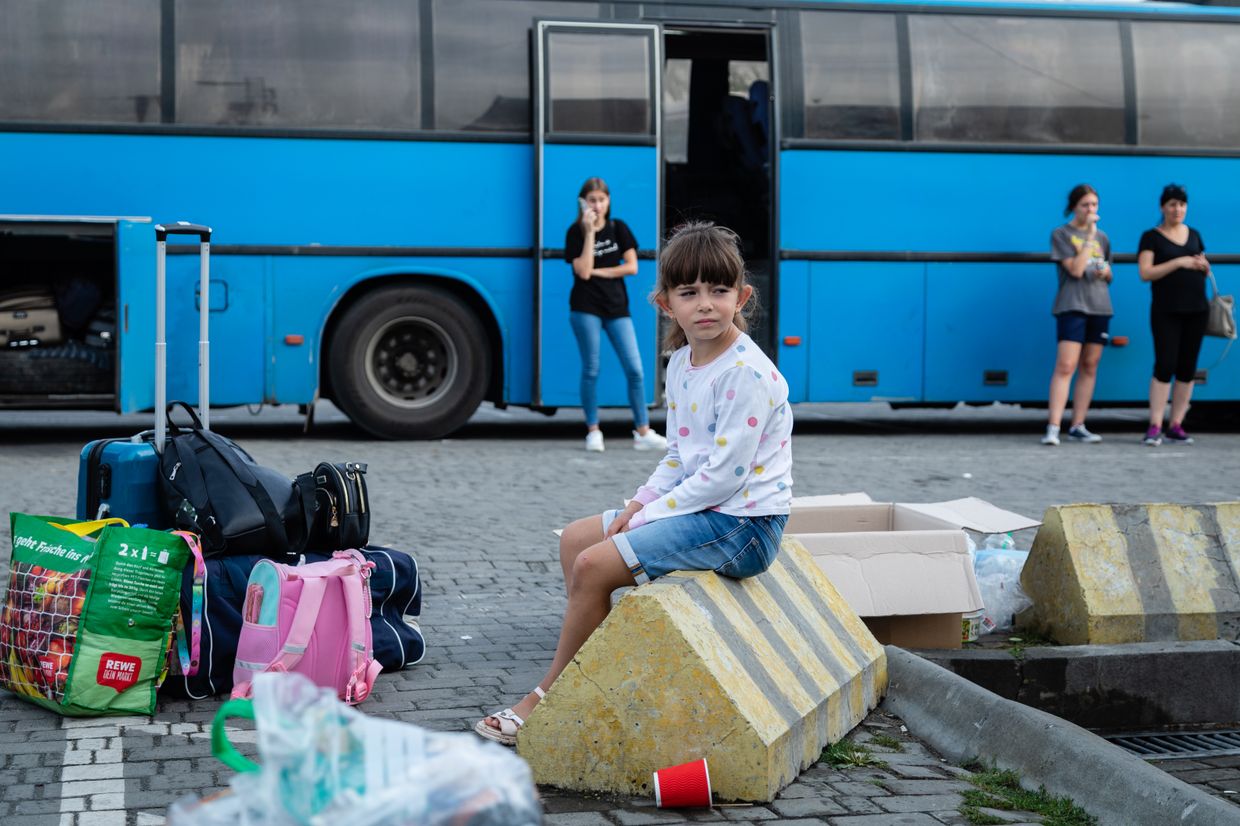 A girl sitting near bags and waiting for the bus in Lviv, Ukraine