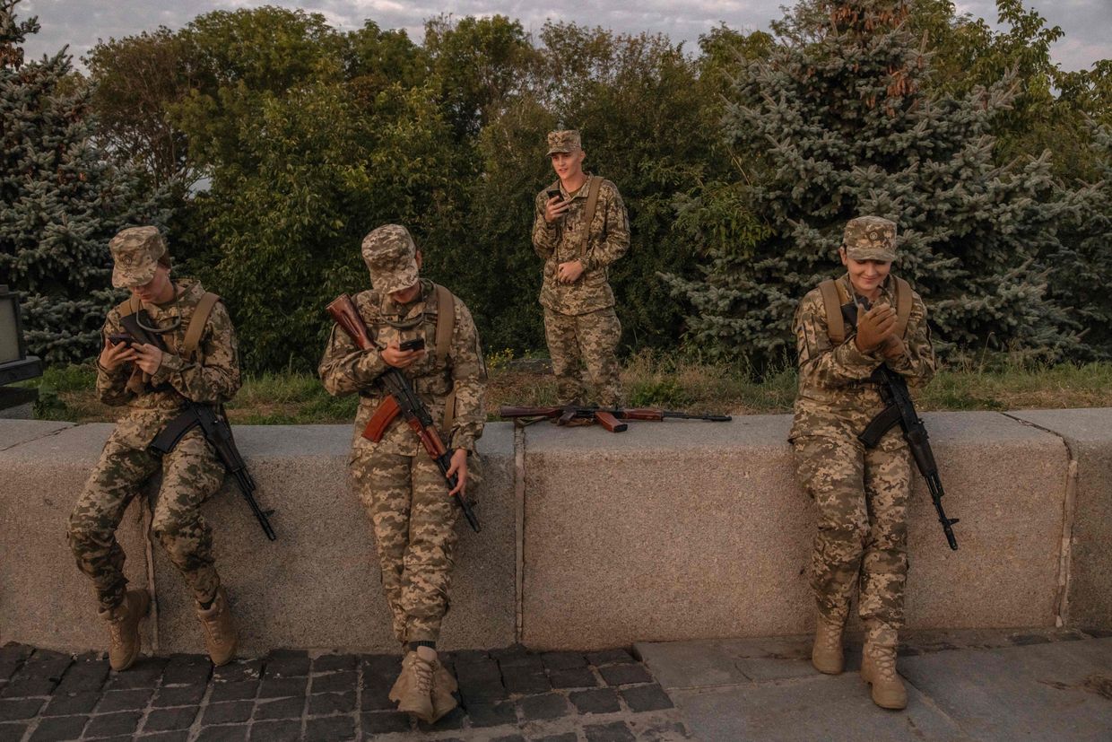 Ukrainian cadets look into their phones after a ceremony for taking the military oath