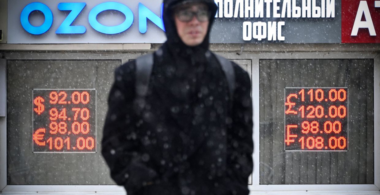 A man walks past a currency exchange office in the snow in central Moscow on Oct. 27, 2023. 