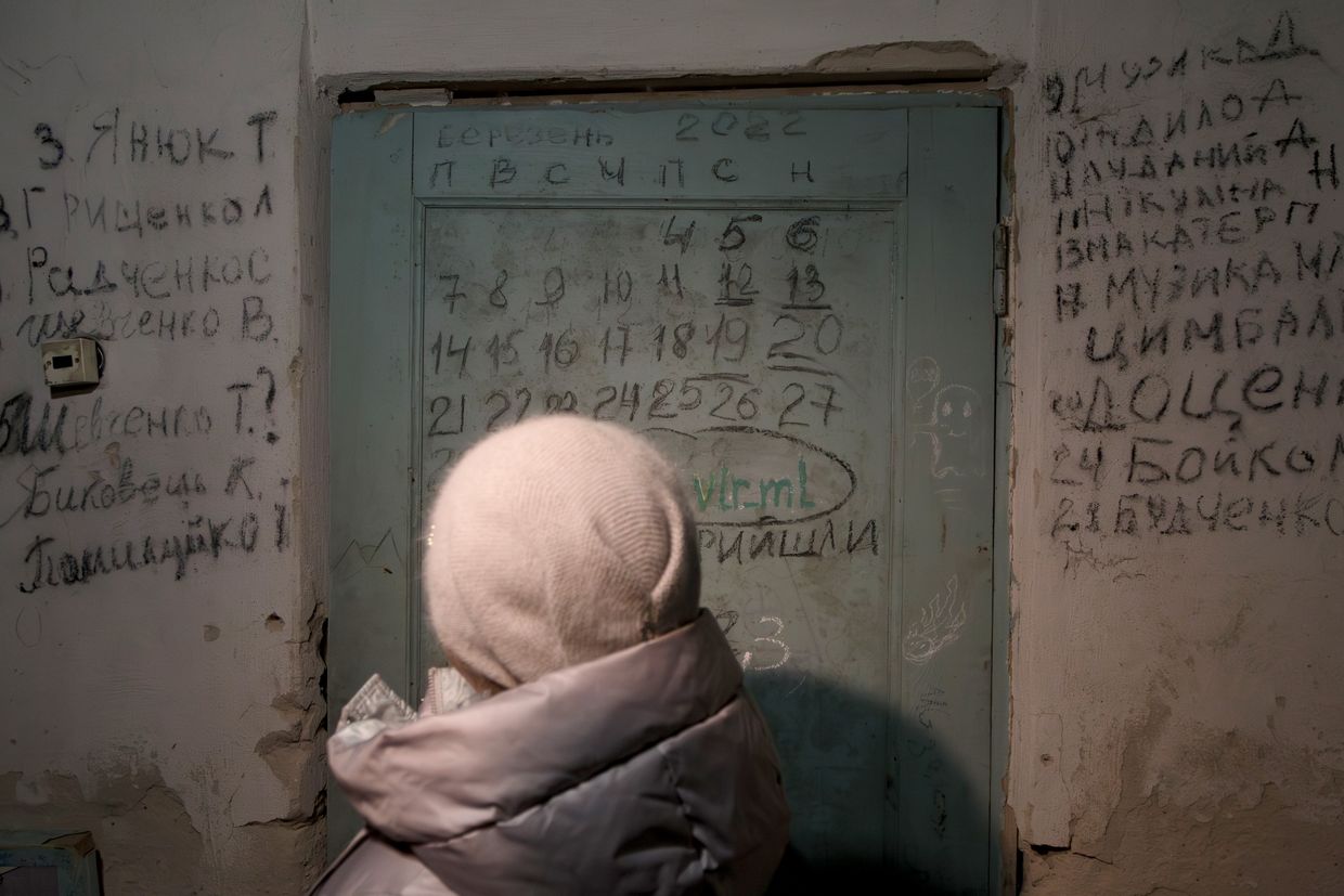 On Jan. 17, 2024, a woman stands before a door with a calendar and names of those who died in the Yahidne school basement, where 300+ were held by Russian occupiers in March 2022.