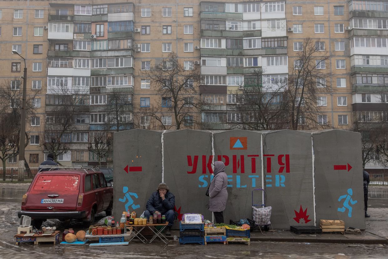 People sell vegetables and other goods next to a bomb shelter at a market in Kramatorsk, Donetsk Oblast