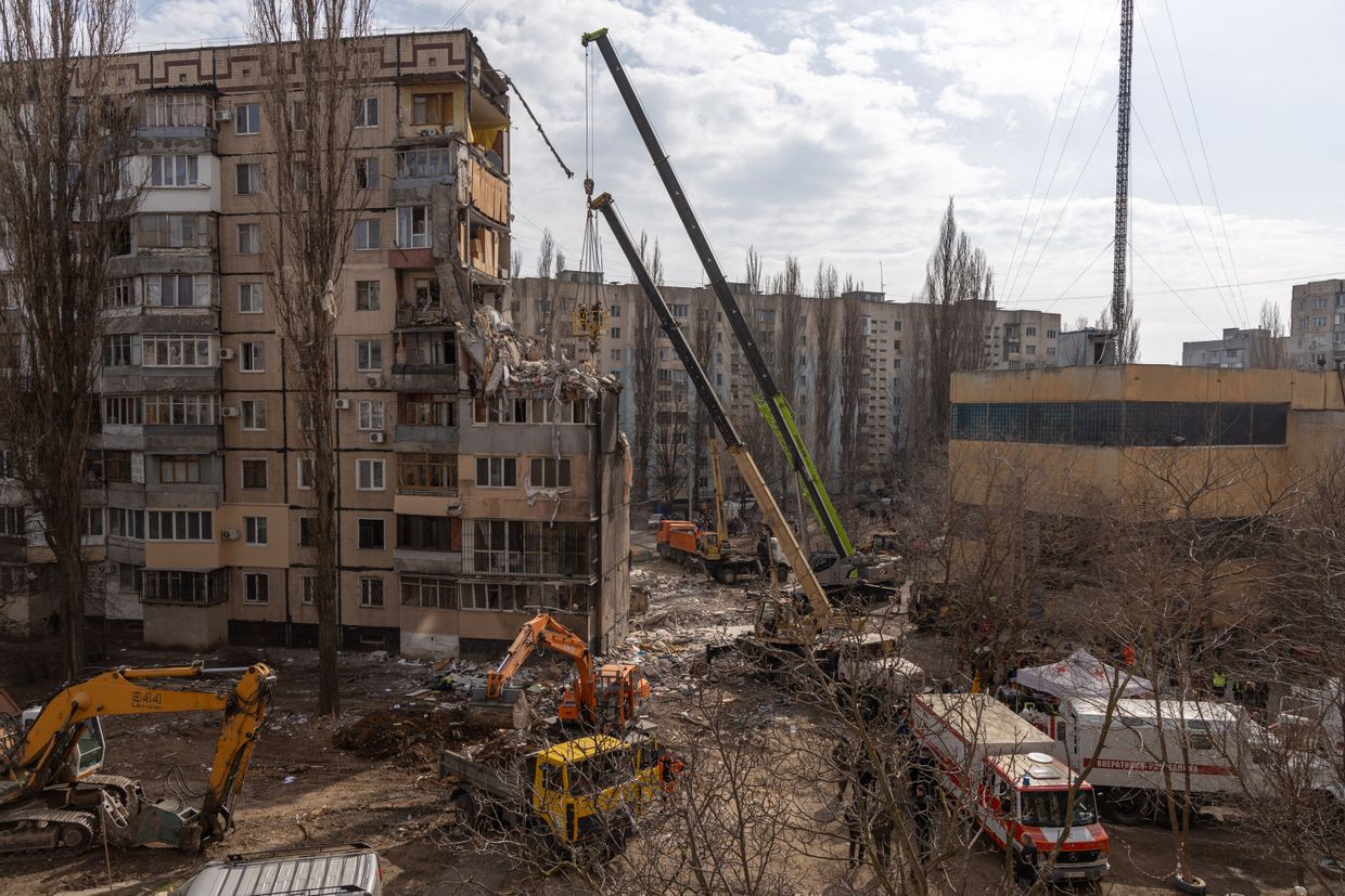 Rescuers clear debris from a multi-story building heavily damaged following a drone strike in Odesa