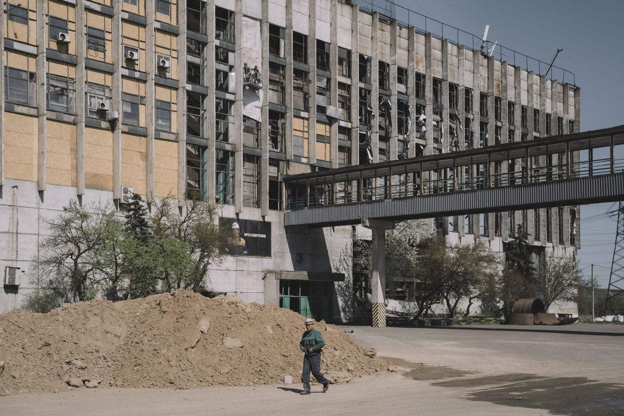 A worker outside a thermal power plant, extensively damaged after a Russian missile attack, at an undisclosed location