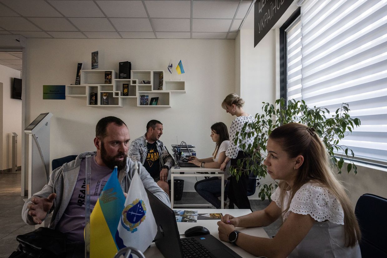 Civilian Oleksii, 34, (L) talks to a recruitment agent in a military recruitment centre in Dnipro