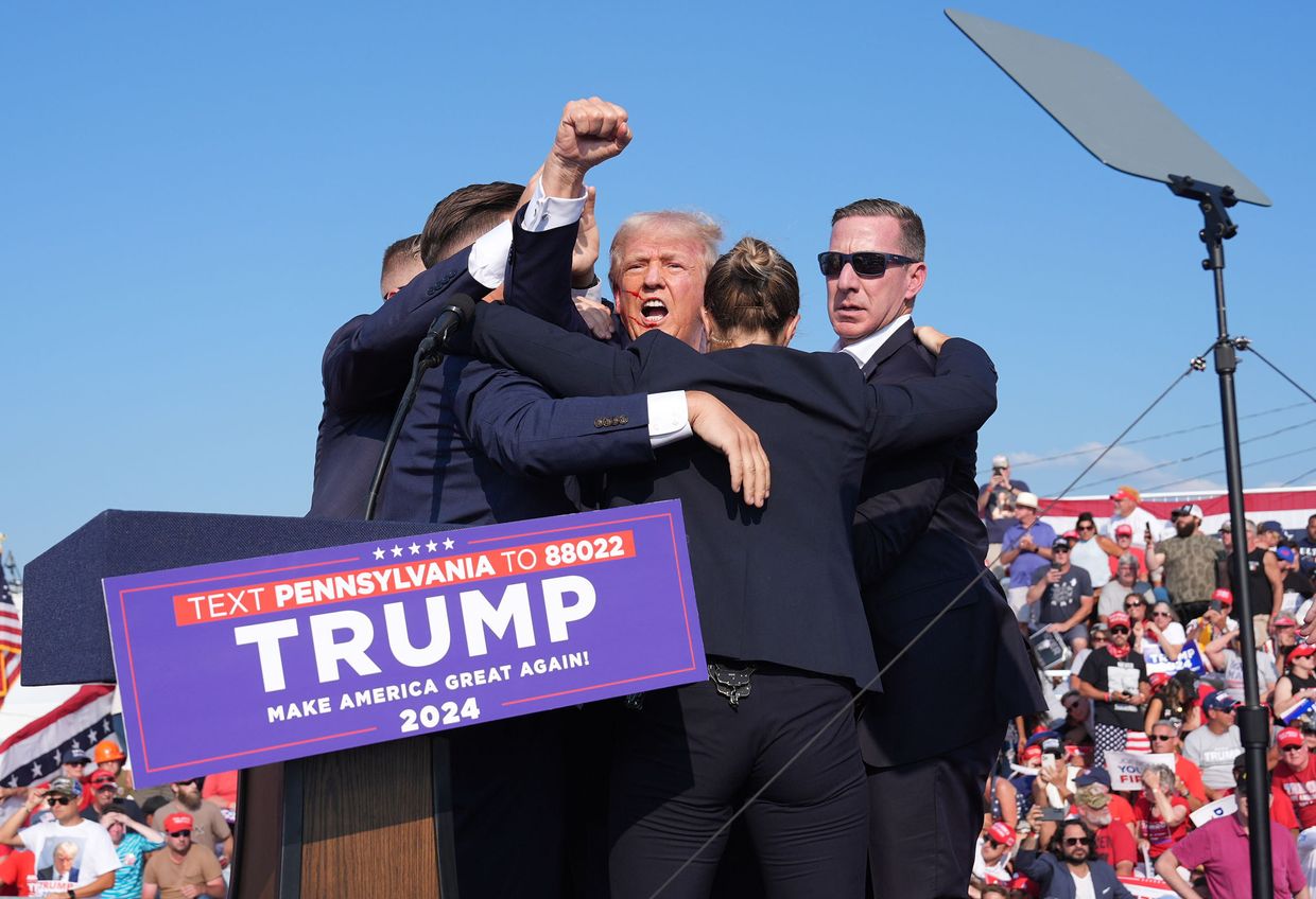 Former president Donald Trump raises his arm with blood on his face during a campaign rally for former President Donald Trump