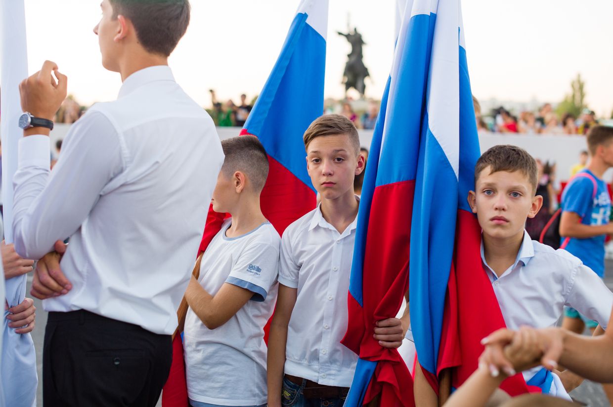 A boy holds a Russian flag for the celebration for the 25th year of "independence day" in Tiraspol