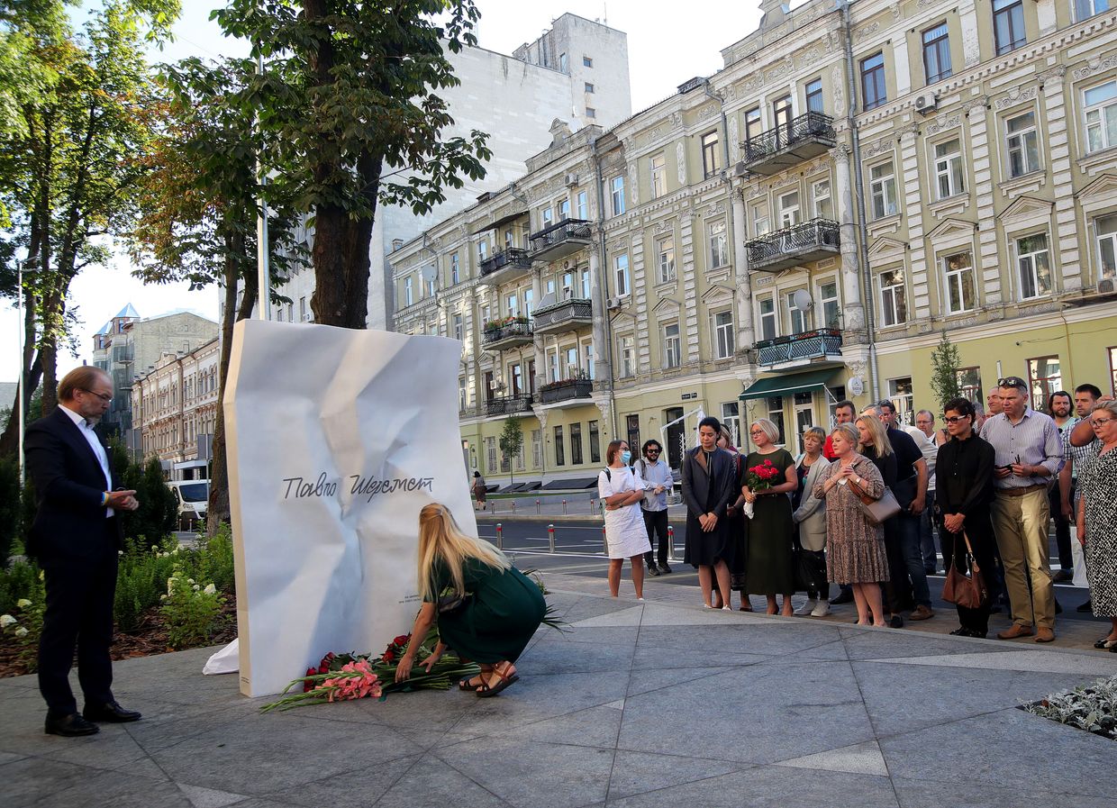 A woman lays flowers at the memorial unveiled in remembrance of journalist Pavel Sheremet