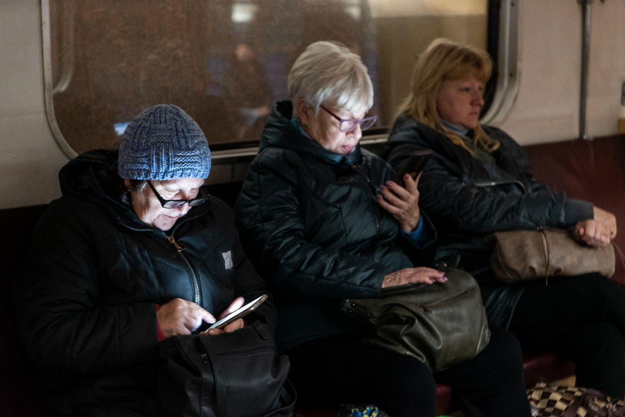 Women look at their telephone in a subway car during the temporary suspension of transport as a result of missile strikes in Kharkiv, Ukraine, on October 31, 2022