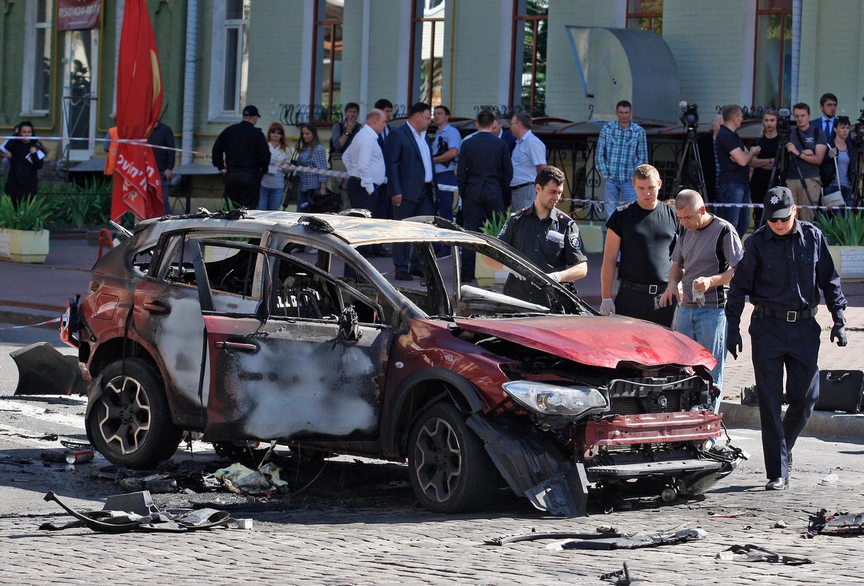 Police experts inspect the damaged car of journalist Pavel Sheremet in Kyiv, Ukraine, on July 20, 2016