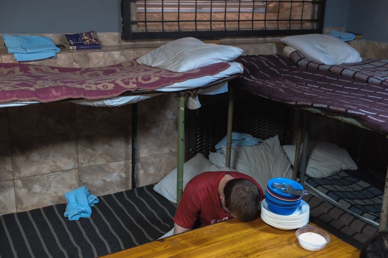 Russian POW rests his head on the table in a POW camp in an undisclosed location