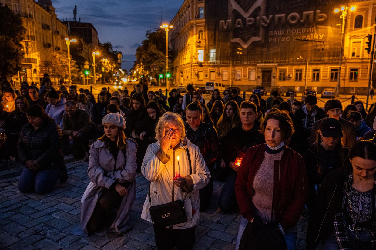 A woman holds a candle during a minute of silence in Kyiv, Ukraine on Sep. 6, 2022