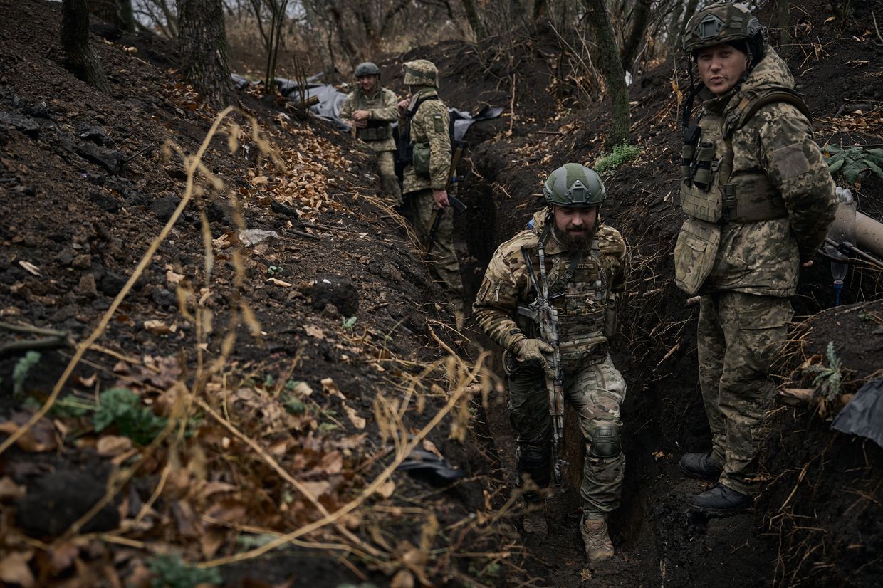 Soldiers of the 58th separate mechanized brigade go to their positions along the trenches, which are covered in mud after the rain in Vuhledar