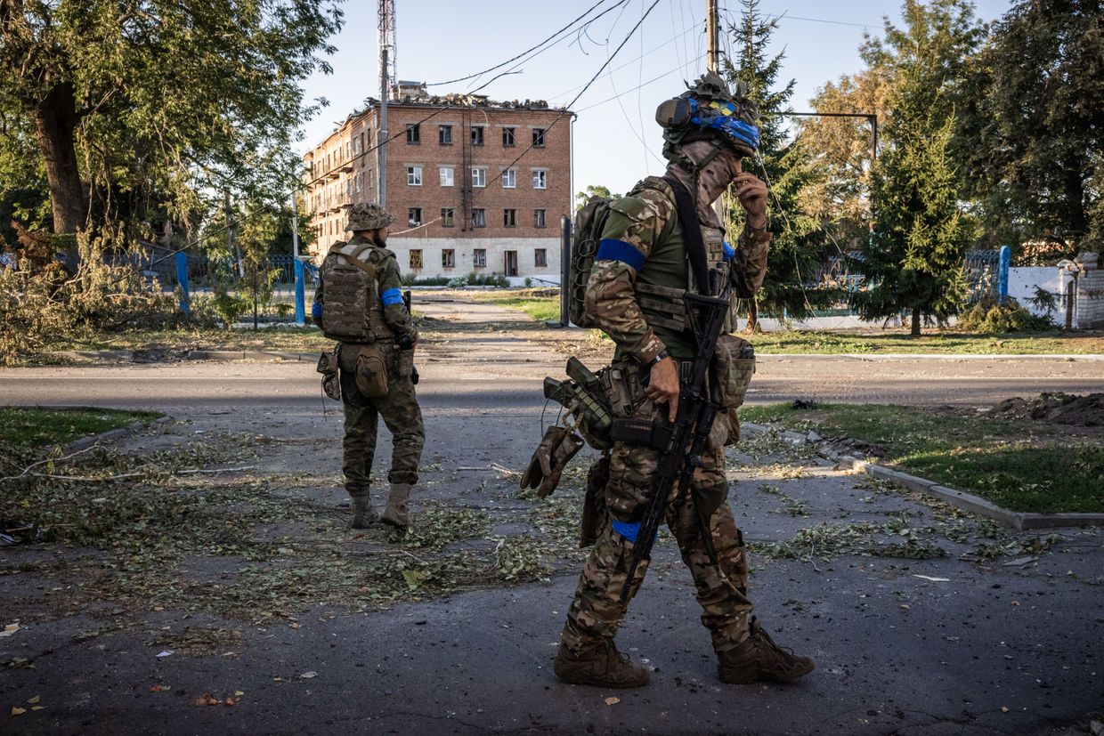 A Ukrainian drone Unit commander with the call sign Boxer (right) walks in the Ukrainian-controlled city of of Sudzha