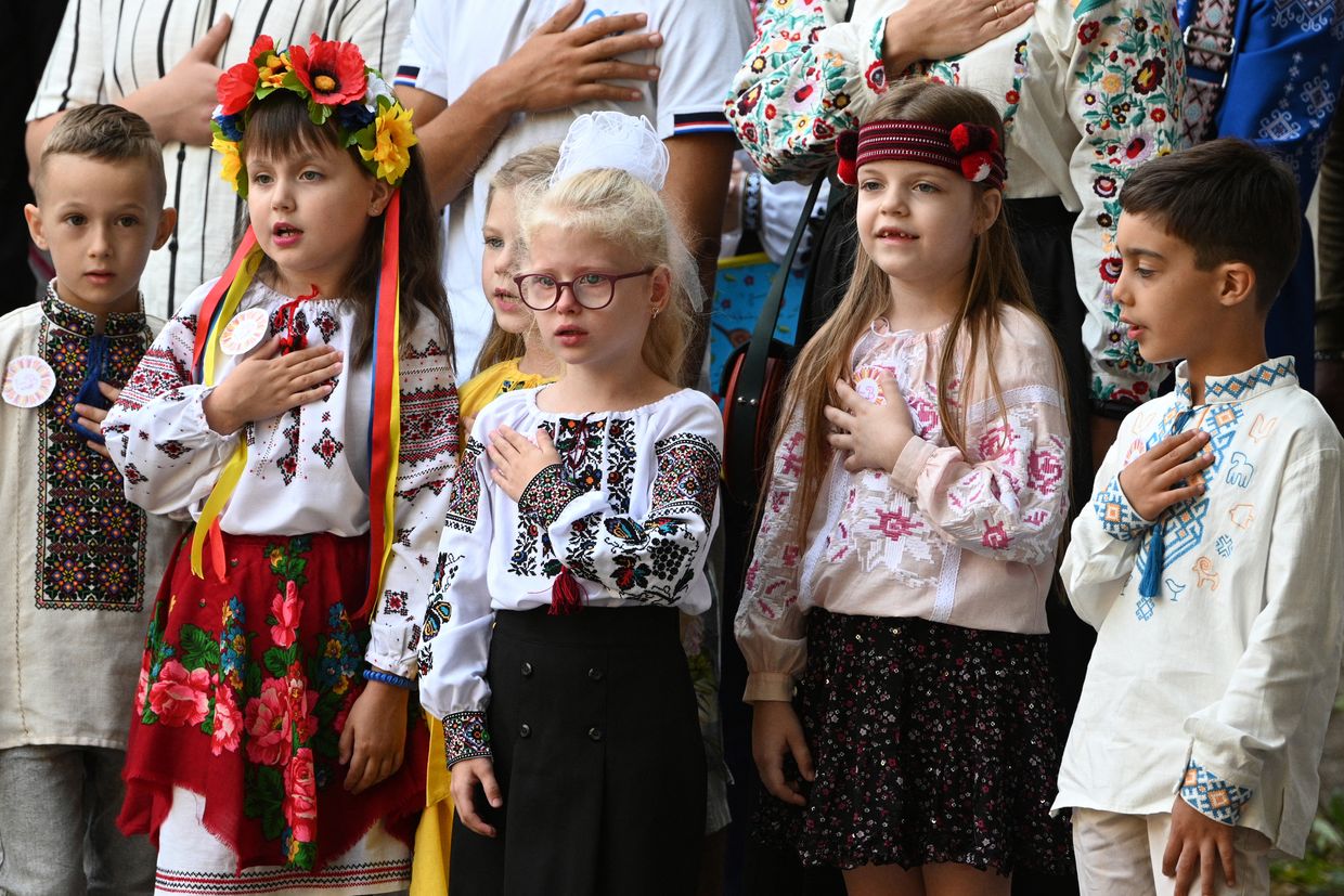 Ukrainian schoolchildren sing the national anthem during a bell ceremony on the first day of the new school