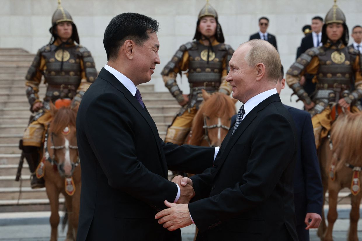 Vladimir Putin and Mongolia's President Ukhnaagiin Khurelsukh shake hands