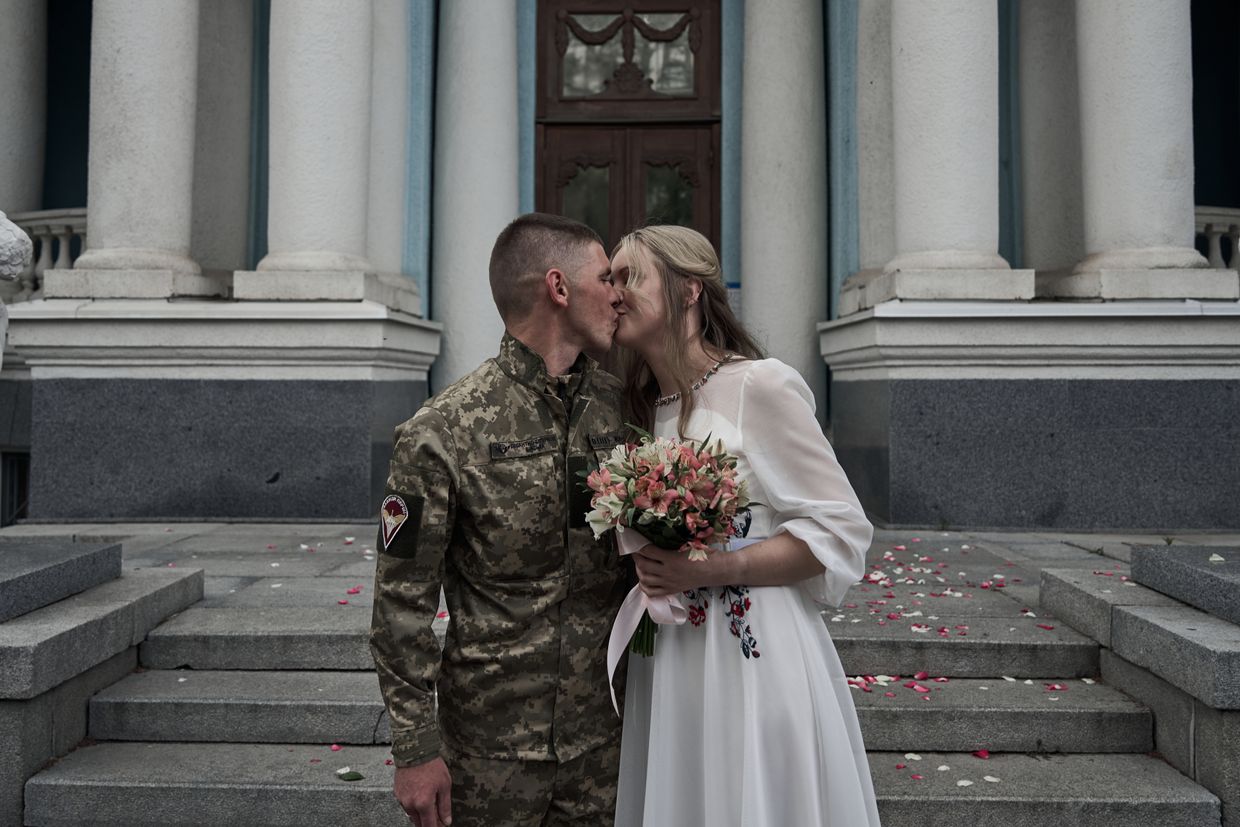 A bride and Groom kiss during their wedding in the city during the war in Kharkiv, Ukraine on May 18, 2024.