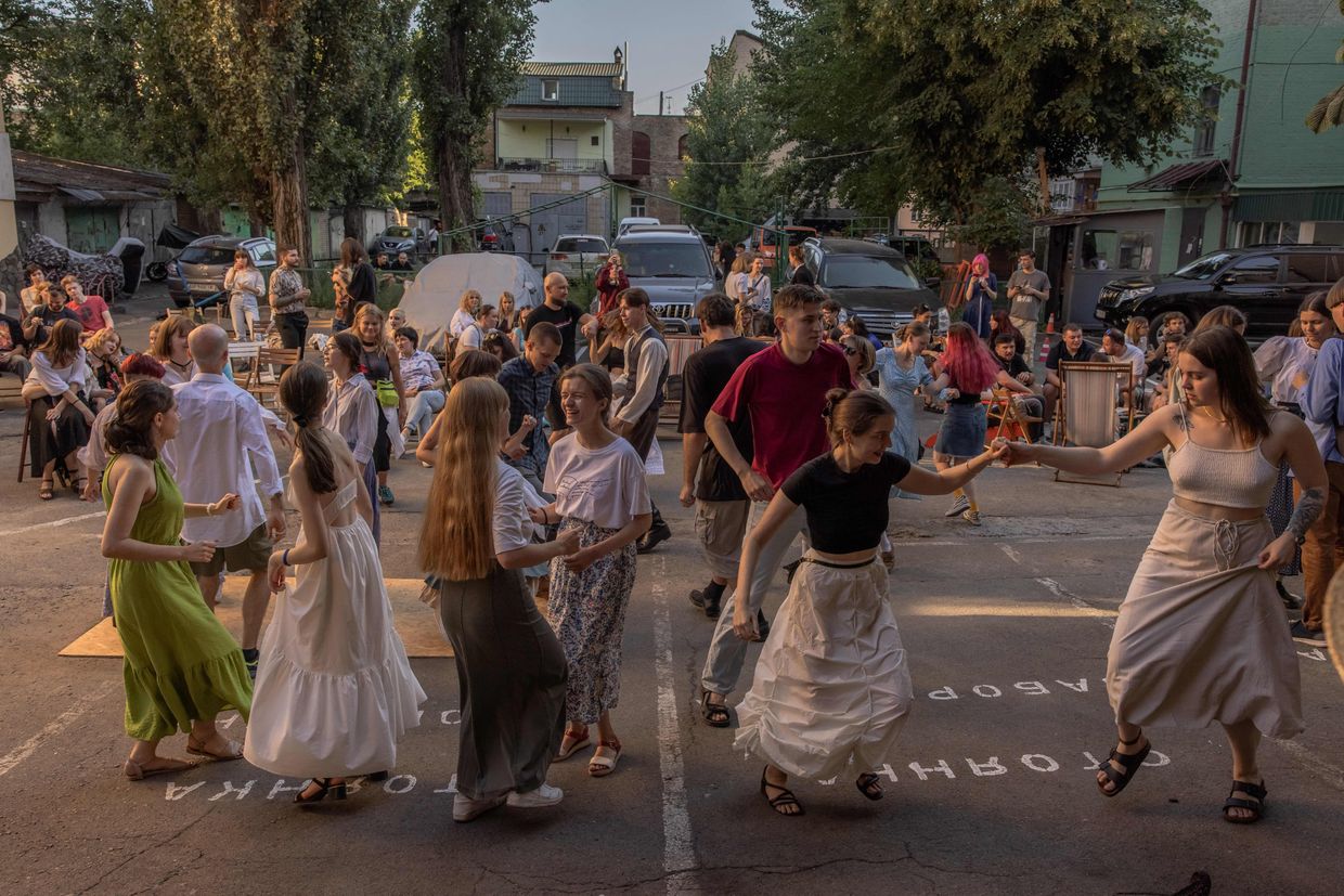 Local residents dance as musicians play folk music at a yard bar in downtown Kyiv, Ukraine, on Aug. 13, 2023