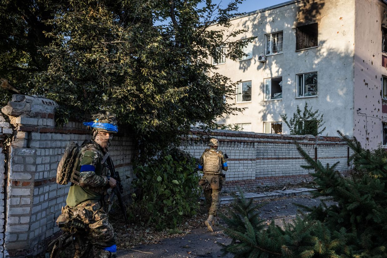 Ukrainian soldiers walk in the Ukrainian-controlled city of Sudzha