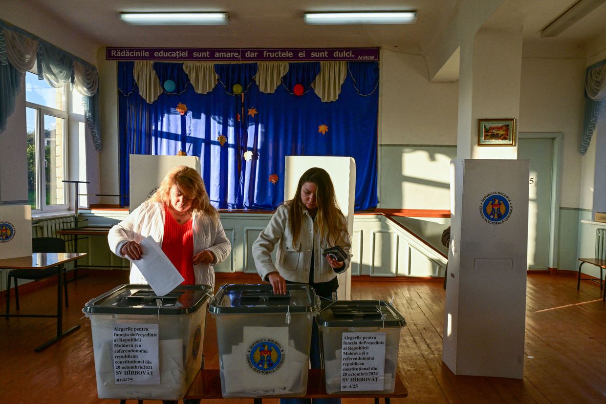  Two women vote in Moldova's presidential election and EU referendum at a polling station in Hirbovat on Oct. 20, 2024.