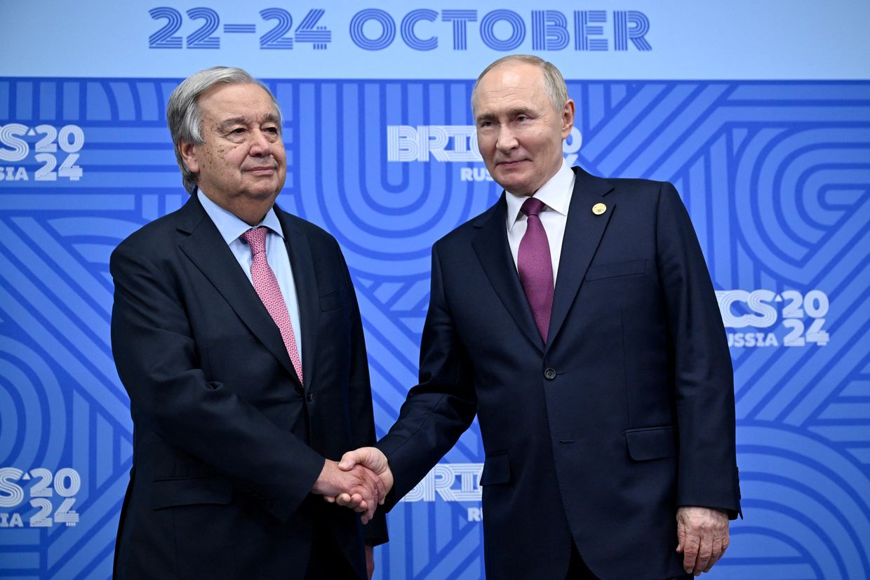 Russian President Vladimir Putin (R) greets United Nations (UN) Secretary General Antonio Guterres