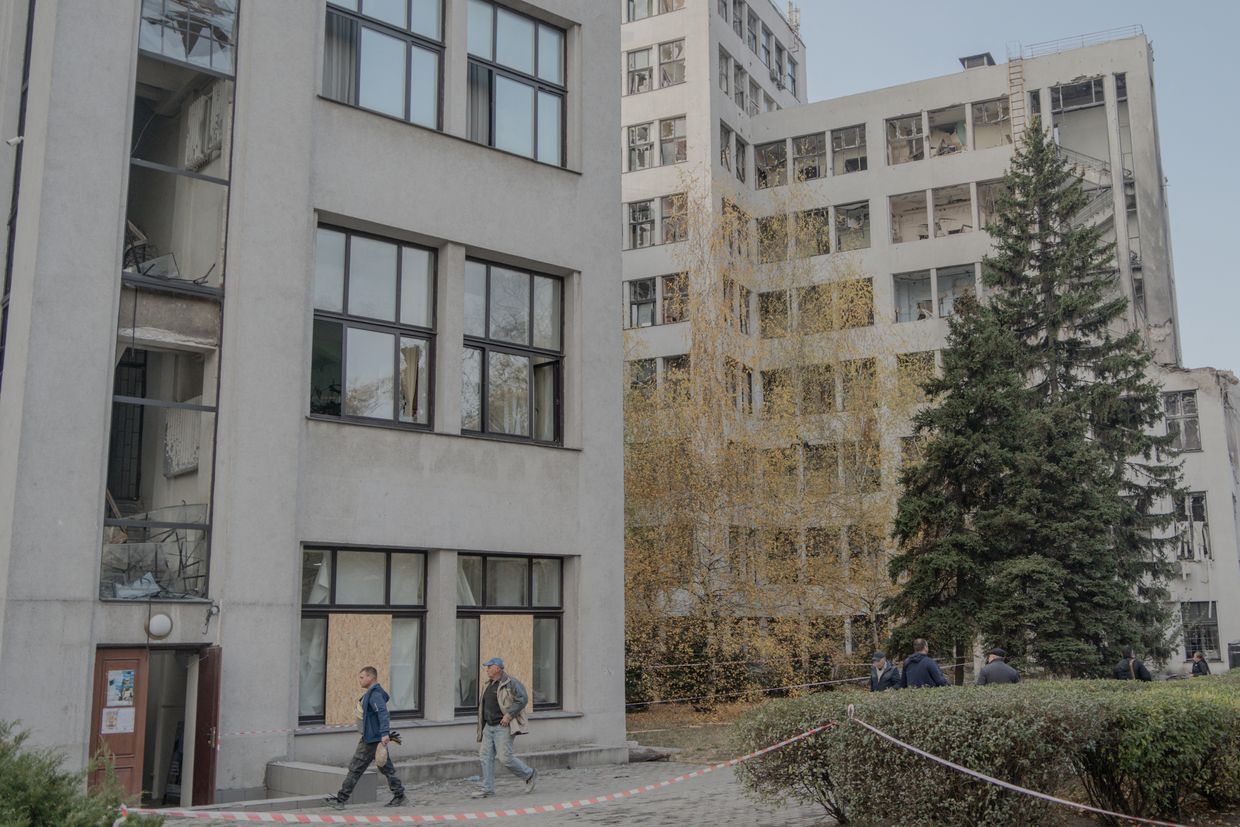 People walk past the damaged Derzhprom building, a historic Soviet skyscraper, after a missile attack in Kharkiv, Ukraine, on Oct. 29, 2024.