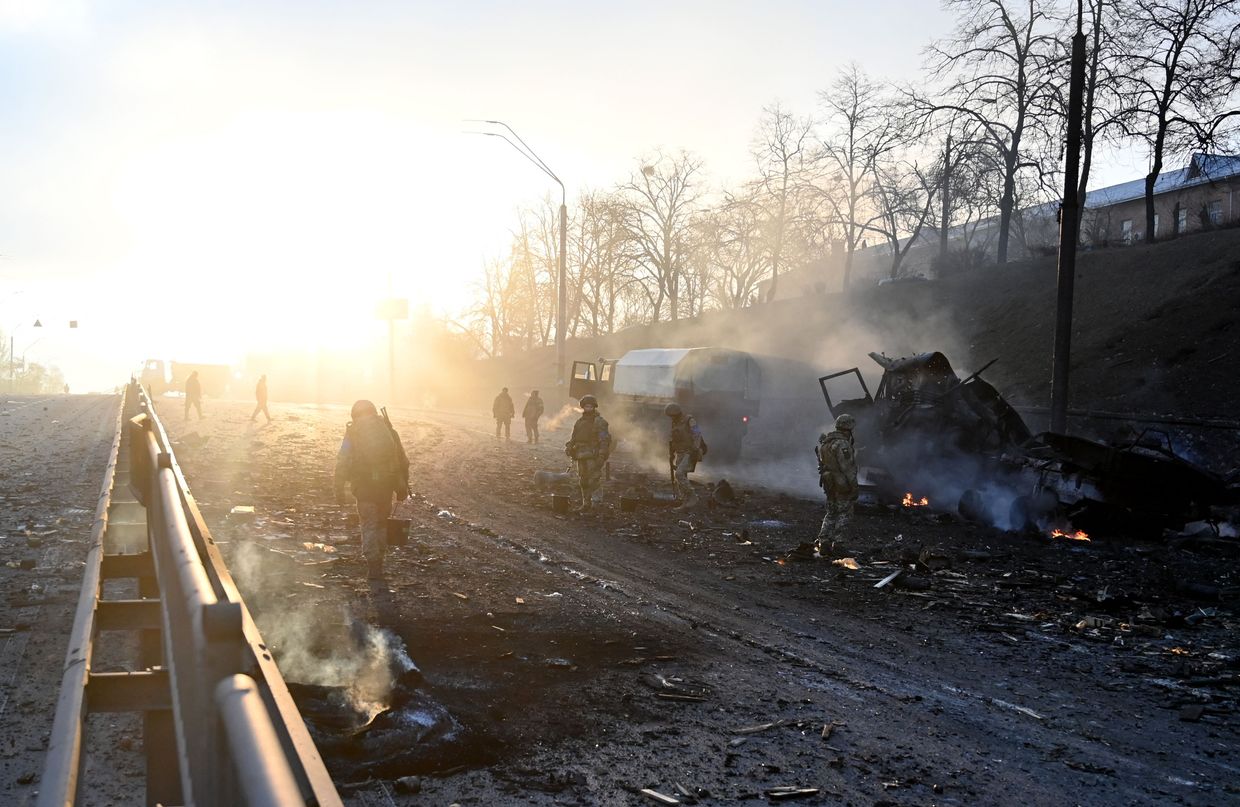 Ukrainian service members look for and collect unexploded shells in Kyiv, Ukraine, on the morning of Feb. 26, 2022. 