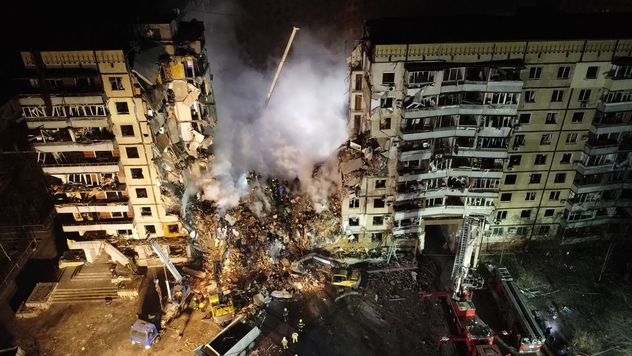 An aerial view shows firefighters conducting search and rescue at a residential building hit by a missile in Dnipro, Ukraine, on Jan. 15, 2023.