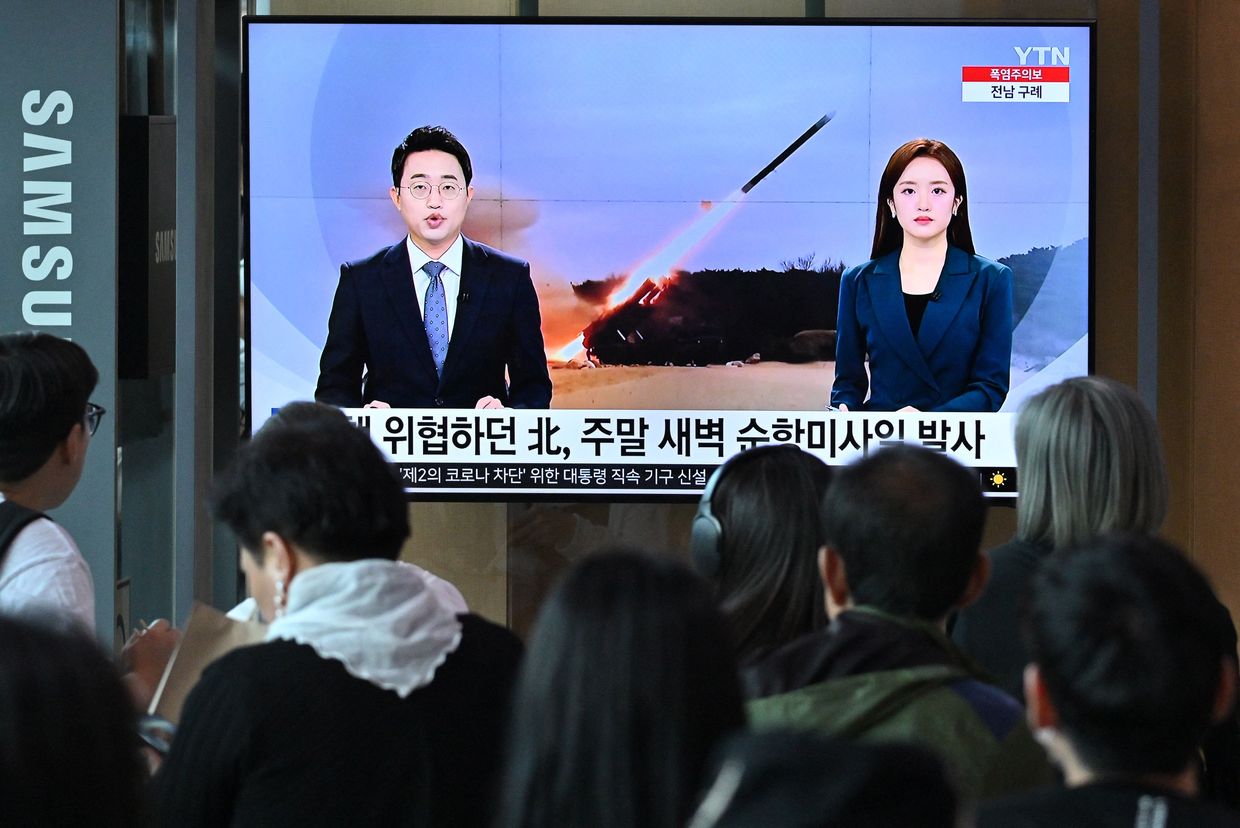 People watch a television screen showing a news broadcast with file footage of a North Korean missile test, at a railway station in Seoul, South Korea on July 22, 2023