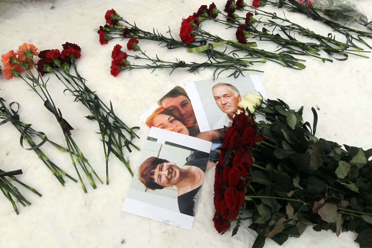 Flowers and photos honor victims of the Russian missile strike at 118 Peremohy Embankment during a memorial in Dnipro, Ukraine, on Jan. 14, 2024.