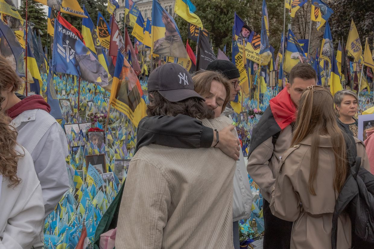 Two attendees hug at a memorial for Ukrainian and foreign fighters on "Defenders Day" in Independence Square, Kyiv, Ukraine, on Oct. 1, 2024.