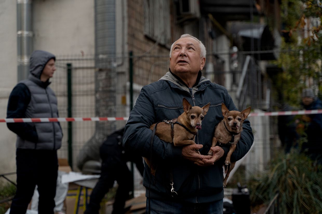 A man with dogs observes a damaged apartment building after a Russian drone attack in Kyiv, Ukraine, on Oct. 29, 2024.