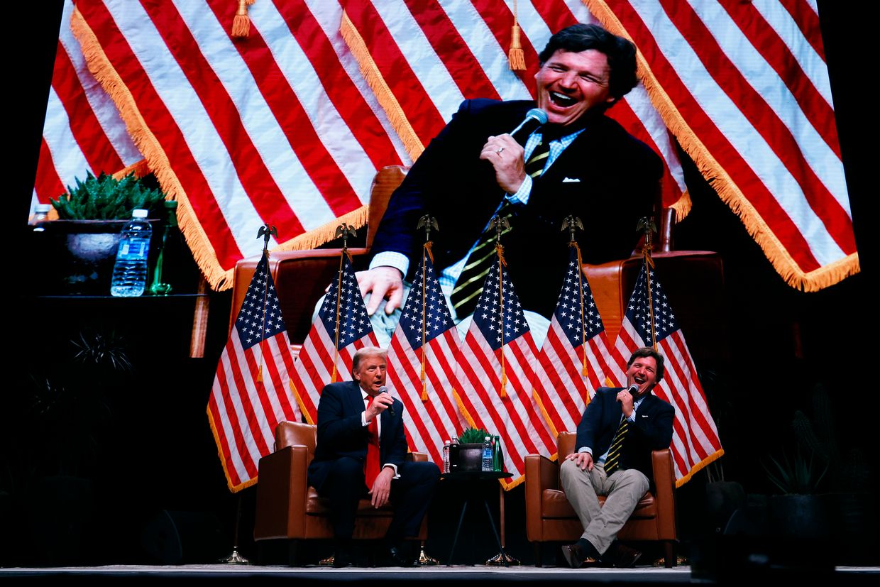  Republican nominee Donald Trump talks with Tucker Carlson during his live tour at Desert Diamond Arena in Phoenix, Arizona, US, on Oct. 31, 2024.