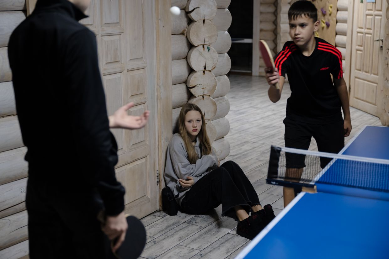 Ameliia Nikulysheva sits on the floor in the hall of the "7Fields" school near Kyiv, Ukraine on Dec. 5, 2024. 