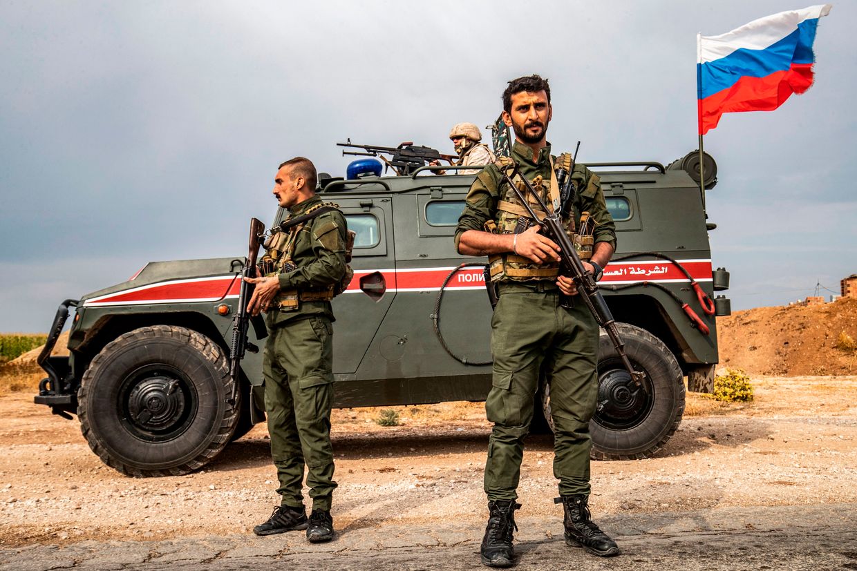 Syrian Kurdish Asayish forces stand before a Russian military police vehicle near Darbasiyah, Syria, on Oct. 25, 2019. 