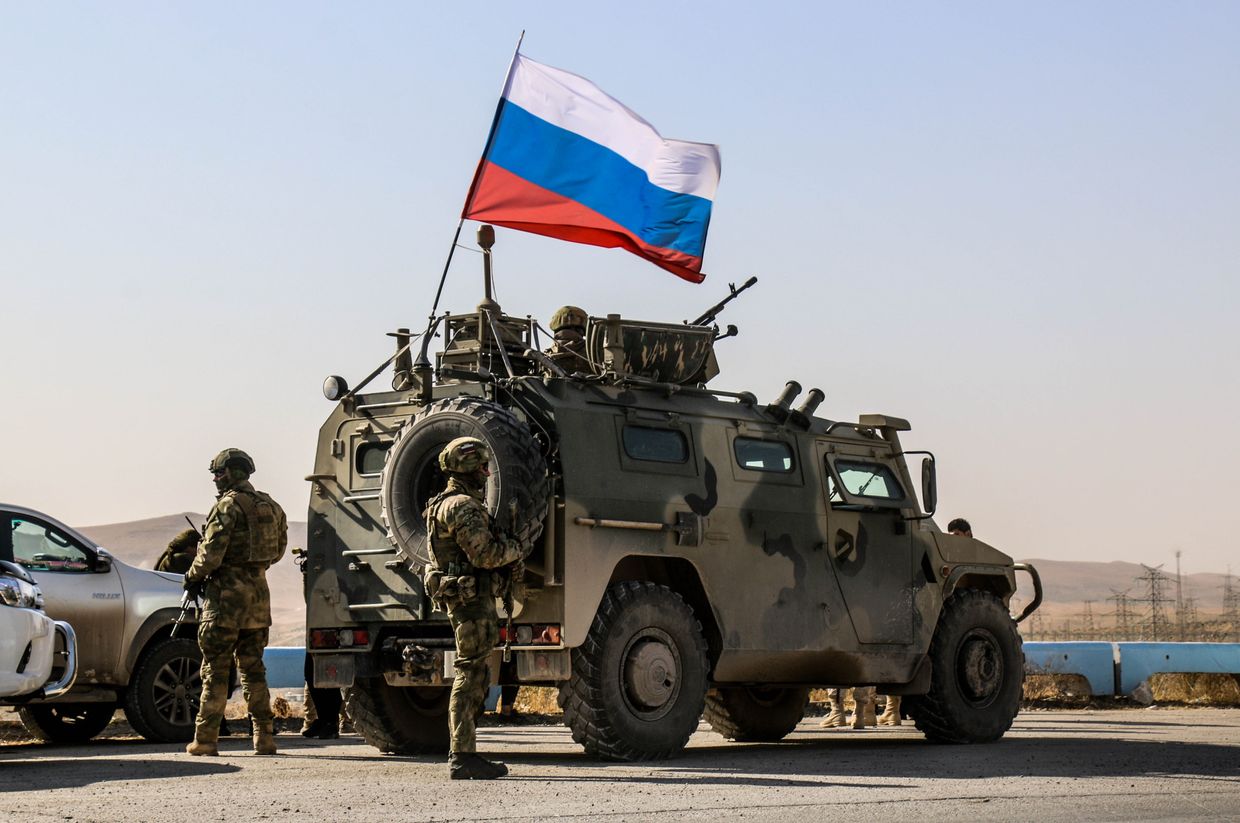  Russian soldiers with flags drive armored vehicles entering the Tishrin Dam base, 90 km east of Aleppo, Syria, on Nov. 18, 2019.