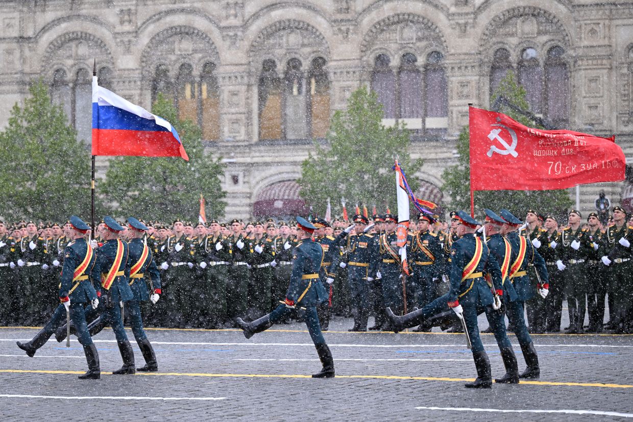  Russian soldiers carrying the national and Soviet flags during a march on Red Square in Moscow, May 9, 2024.