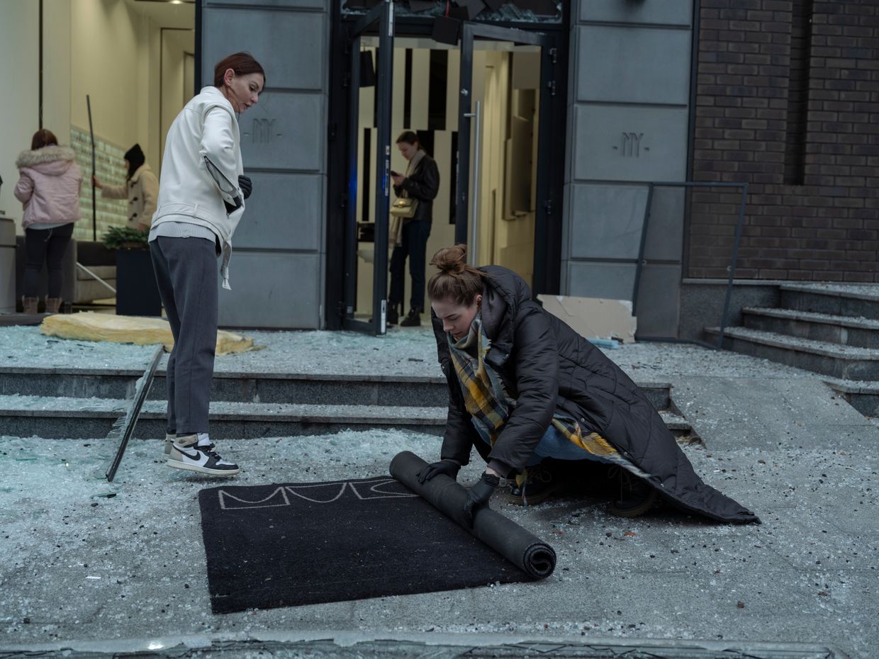 Shopkeepers are cleaning a rug from glass shards after a missile strike in Kyiv, Ukraine, on Dec. 20, 2024.