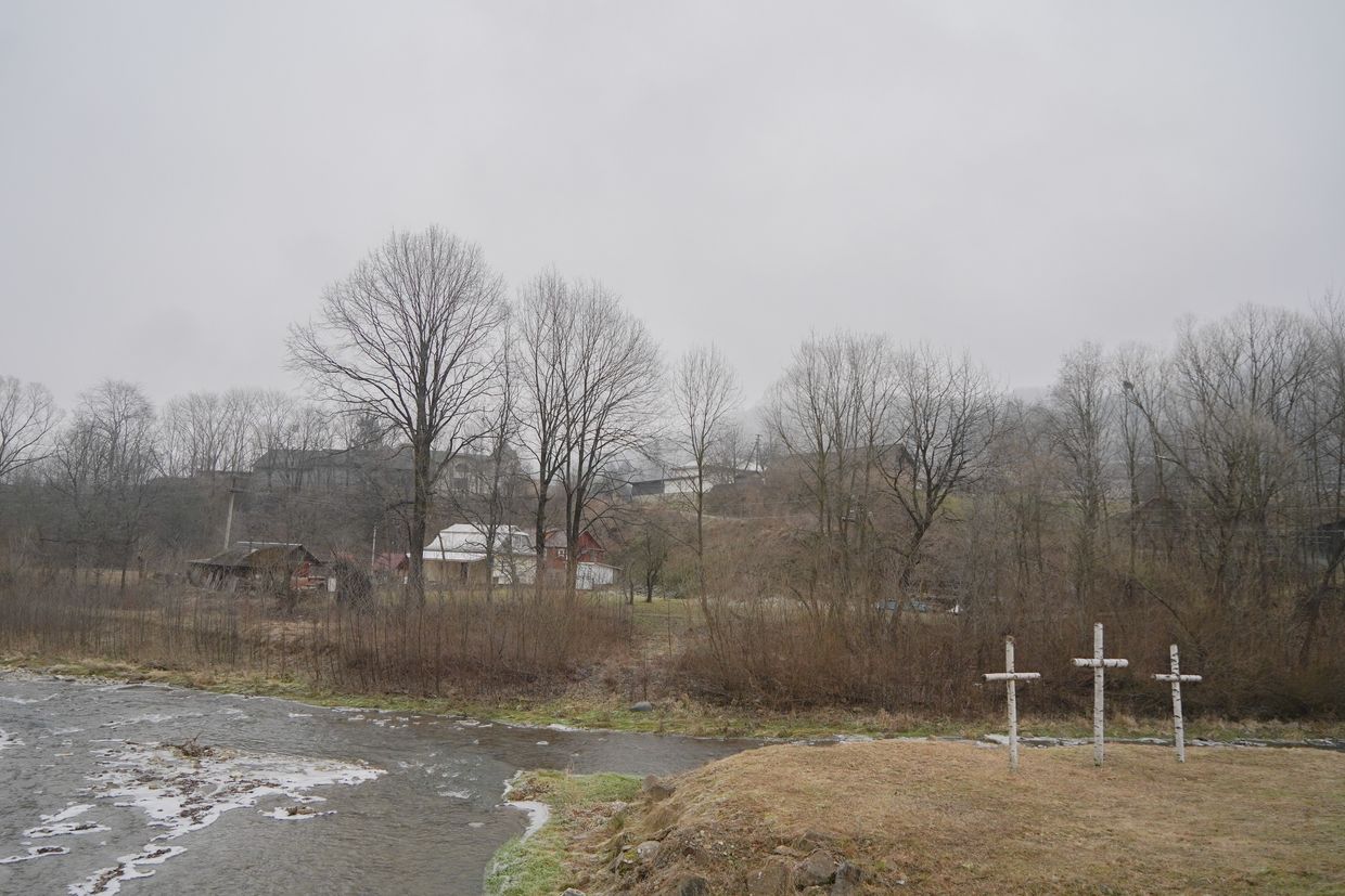 Three wooden crosses on the bank of the river in Sokolivka in Ivano-Frankivsk Oblast, Ukraine on Dec. 23, 2024.