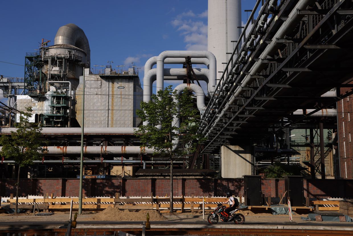 A man on a scooter rides past the Klingenberg natural gas-powered thermal power station in Berlin, Germany, on July 4, 2022.