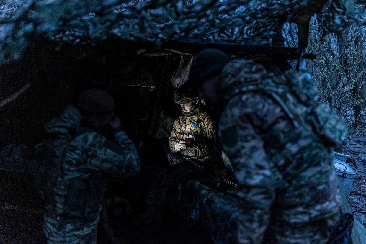 A Ukrainian soldier works with a computer next to a shelter in his fighting position in the direction of Bakhmut, Donetsk Oblast, Ukraine, Nov. 18, 2023. 