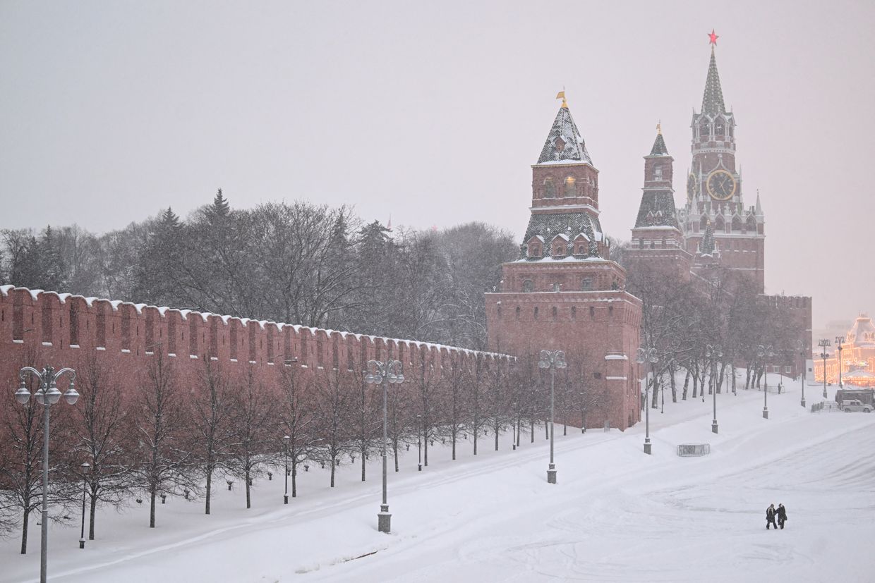 People walk on the edge of Red Square outside the Kremlin during heavy snowfall in Moscow, Russia, on Feb. 7, 2024. 