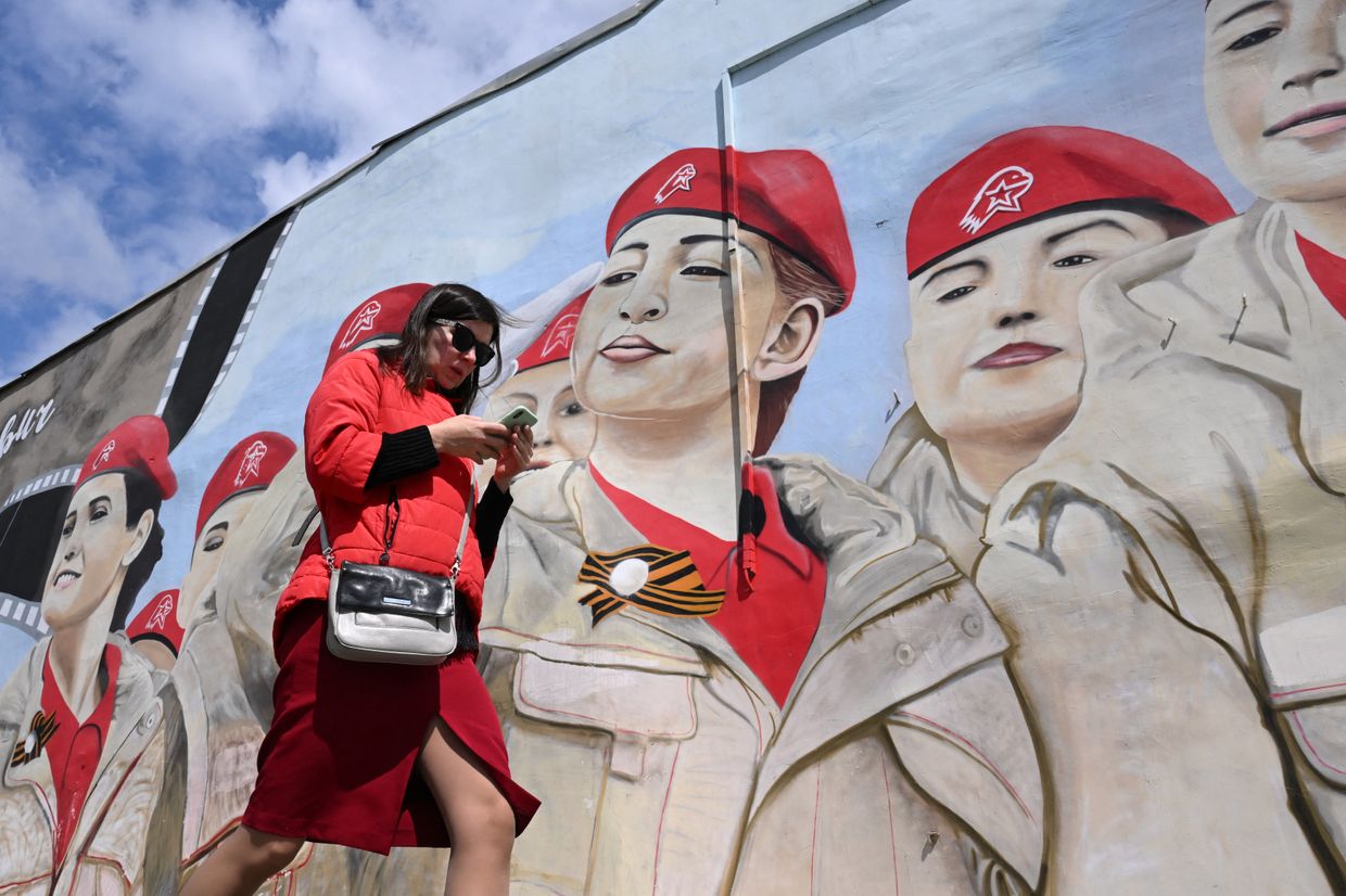 A woman walks past a mural of Russia's Yunarmiya youth movement in Moscow, Russia, on May 14, 2024.