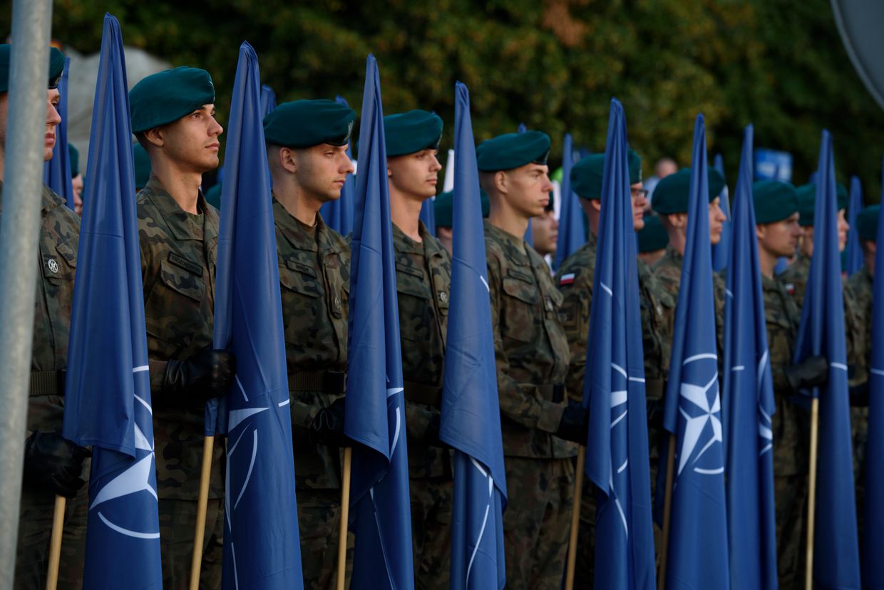 Members of the Polish armed forces hold NATO flags during a rehearsal before National Army Day in Warsaw, Poland, on Aug. 11, 2024. 