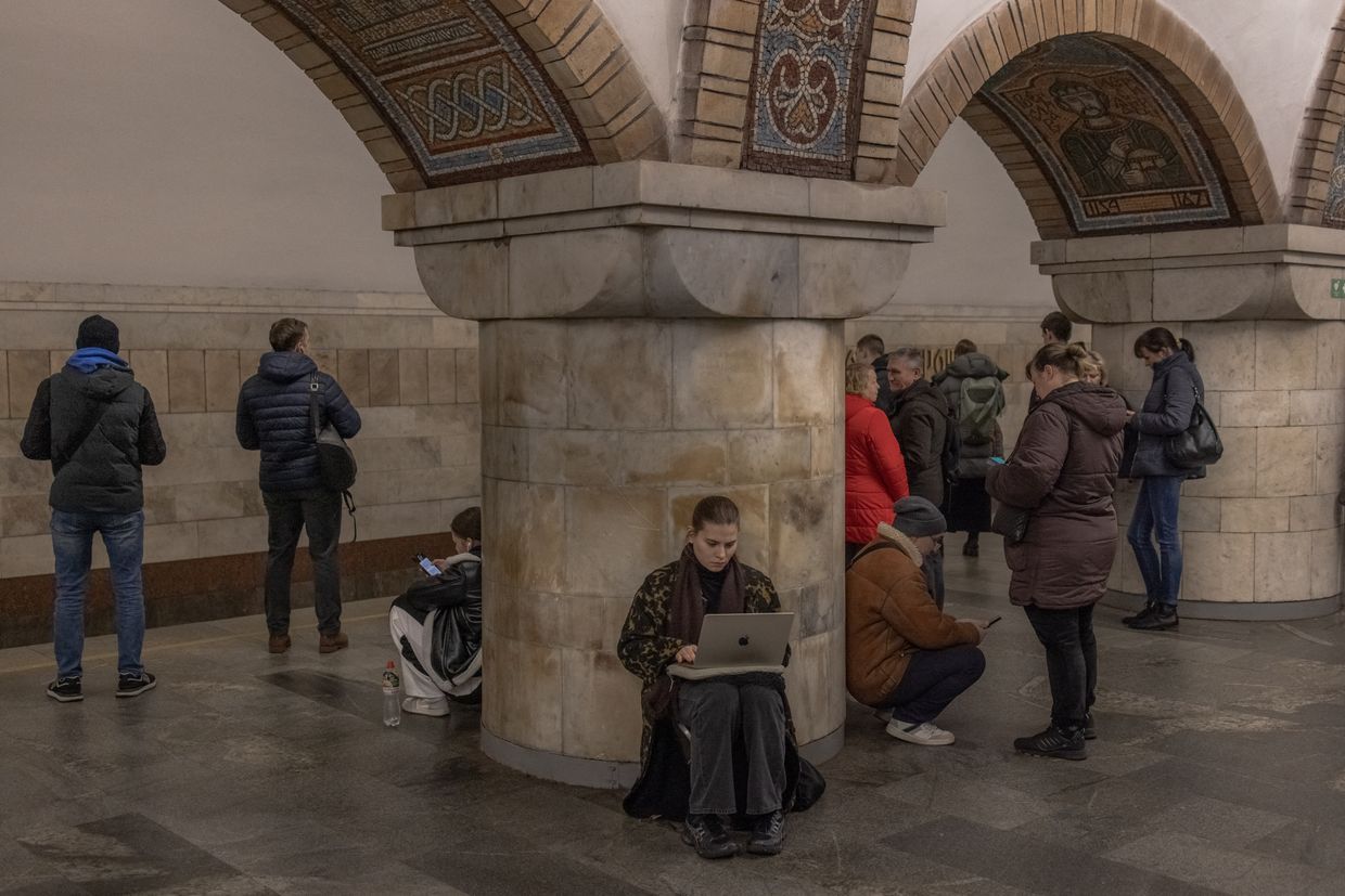 A woman uses her laptop as she takes shelter in a metro station during an air strike alarm in Kyiv, Ukraine, on Nov. 20, 2024.