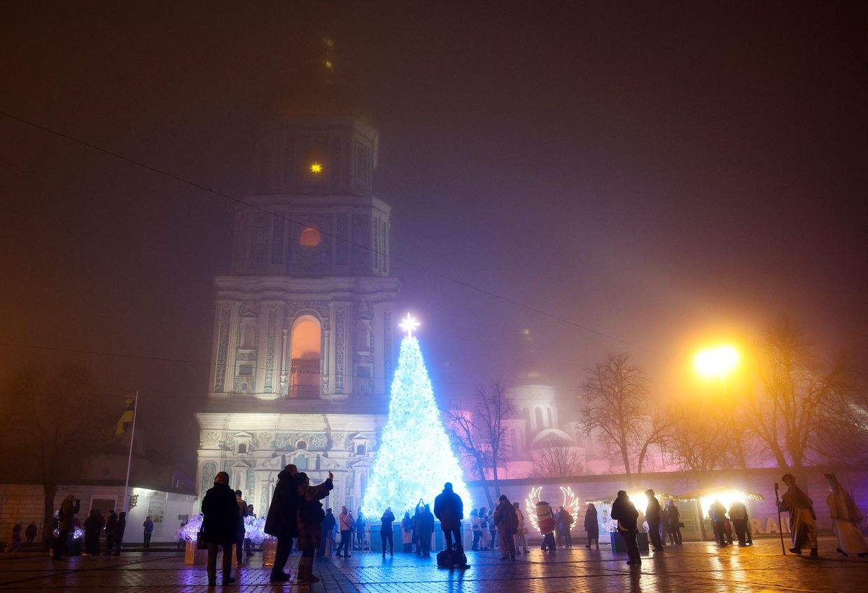 Local residents walk and take photos near the Christmas tree in Sophia Square in Kyiv, Ukraine, on Dec. 24, 2024, amid the Russian invasion.